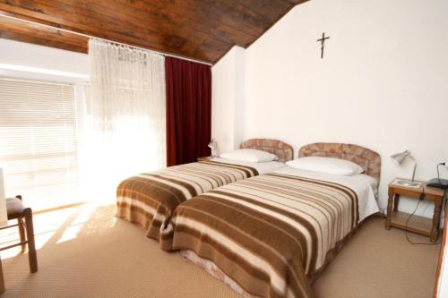twee bedden in een kamer met een kruis aan de muur bij Rooms with a swimming pool Preko, Ugljan - 8180 in Preko