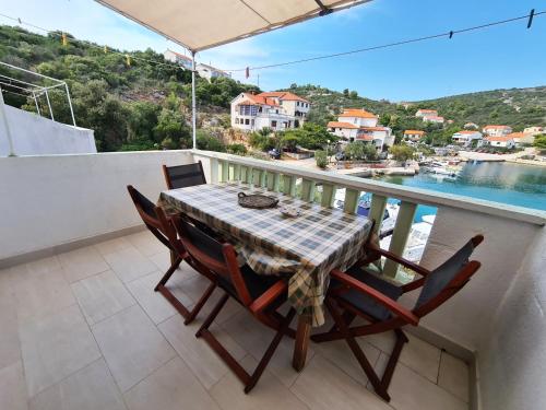 una mesa y sillas en un balcón con vistas al agua en Apartments and rooms by the sea Zaglav, Dugi otok - 8170, en Sali