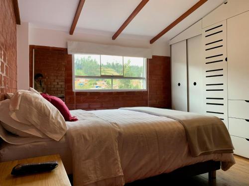 um quarto com uma cama grande e uma janela em Departamentos Huaraz & Caraz em Huaraz