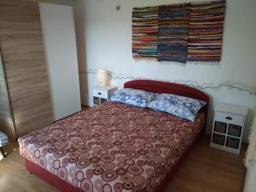 Schlafzimmer mit einem Bett mit einer roten Tagesdecke in der Unterkunft Apartments with a parking space Ugljan - 8527 in Ugljan
