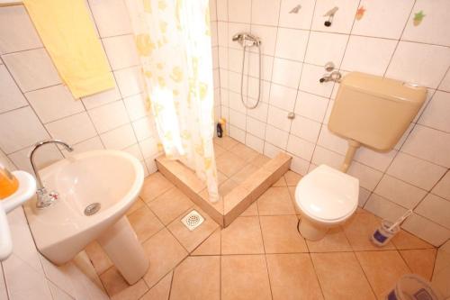 uma casa de banho com um chuveiro, um WC e um lavatório. em Apartments by the sea Tkon, Pasman - 8303 em Tkon