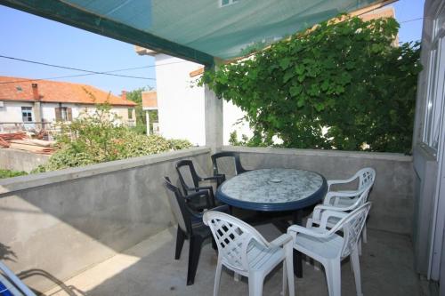 einen Tisch und Stühle auf einer Terrasse in der Unterkunft Apartments by the sea Tkon, Pasman - 8303 in Tkon