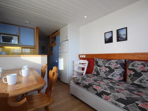 sypialnia z łóżkiem i stołem oraz kuchnią w obiekcie Duplex au calme avec balcon - 6 pers - FR-1-346-335 w mieście Arc 1800