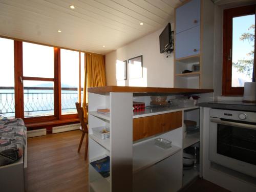 une cuisine avec des placards blancs et une vue sur l'eau dans l'établissement Duplex au calme avec balcon - 6 pers - FR-1-346-335, à Arc 1800