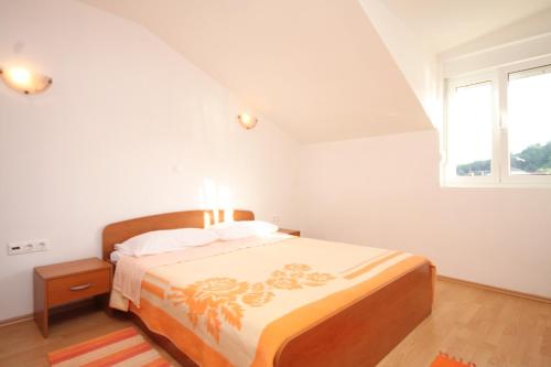 a white bedroom with a bed and a window at Apartment Kukljica 8478a in Kukljica