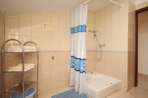 a bathroom with a shower and a toilet and a tub at Apartment Kukljica 8478a in Kukljica