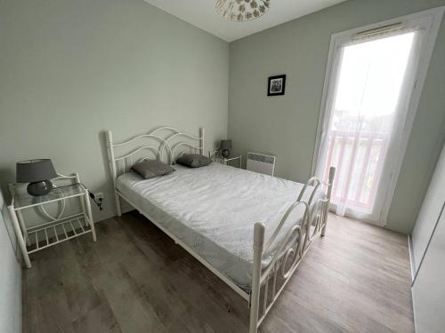 une chambre avec un lit blanc et une fenêtre dans l'établissement T2 Confortable à Cambo-les-Bains, 1er Étage, Parking, Wi-Fi, Proche Centre, Quartier Calme - FR-1-495-103, à Cambo-les-Bains