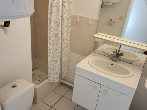 La salle de bains blanche est pourvue d'un lavabo et d'une douche. dans l'établissement Studio Cabourg, 1 pièce, 2 personnes - FR-1-465-83, à Cabourg