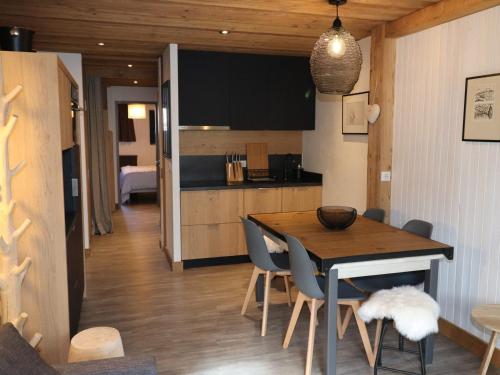 une cuisine et une salle à manger avec une table et des chaises dans l'établissement Appartement Charme · Rénové · Balcon Sud · Au Pied des Pistes · Tignes Val Claret - FR-1-502-365, à Tignes
