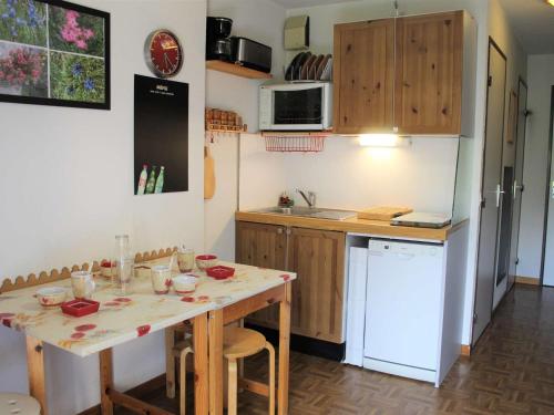 une cuisine avec une table et un comptoir dans l'établissement Charmant T2 à Vars Sainte Marie, balcon sud, à 300m des pistes, navettes gratuites, animaux acceptés - FR-1-330B-196, à Vars