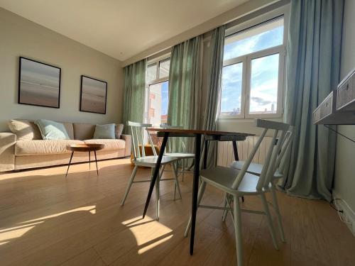 un salon avec une table, des chaises et un canapé dans l'établissement Studio lumineux avec balcon à Saint-Jean-de-Luz, à deux pas de la plage et des commerces - FR-1-239-839, à Saint-Jean-de-Luz