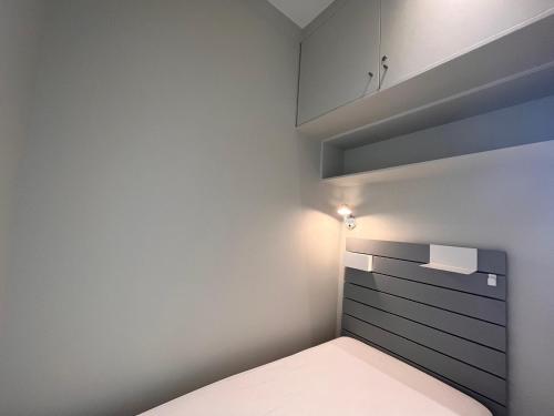 une petite chambre avec un lit et une armoire dans l'établissement Studio lumineux avec balcon à Saint-Jean-de-Luz, à deux pas de la plage et des commerces - FR-1-239-839, à Saint-Jean-de-Luz