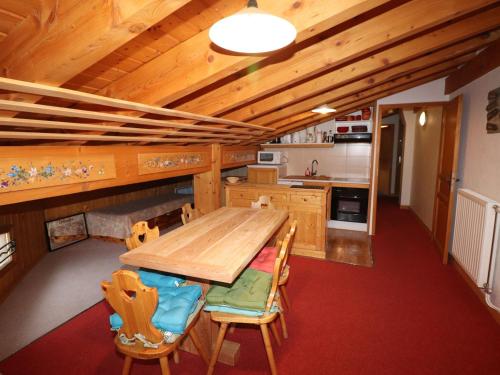 une cuisine avec une table et des chaises en bois dans l'établissement Appartement confort 6 pers, proche pistes, balcon - FR-1-502-373, à Tignes