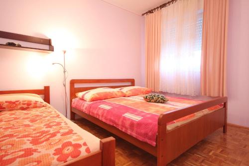sypialnia z 2 łóżkami i oknem w obiekcie Apartments by the sea Kastel Stafilic, Kastela - 8621 w mieście Kaštela