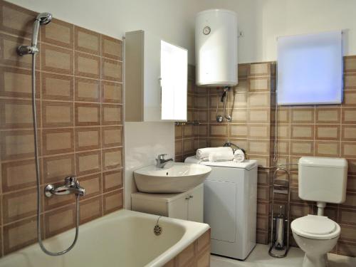 a bathroom with a sink and a tub and a toilet at Apartments by the sea Razanj, Rogoznica - 8365 in Rogoznica