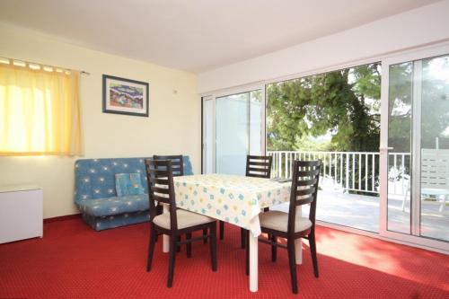 ein Esszimmer mit einem Tisch und Stühlen sowie einem Balkon in der Unterkunft Apartments by the sea Pasadur, Lastovo - 8388 in Lastovo