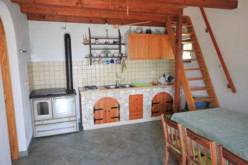 a small kitchen with a stove and a ladder at Seaside house for families with children Cove Soline, Pasman - 8482 in Kraj