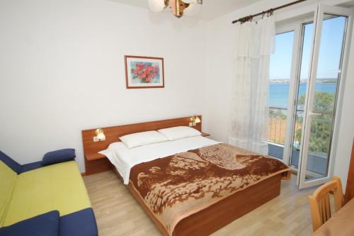 1 dormitorio con cama y ventana grande en Apartments and rooms by the sea Tkon, Pasman - 8377, en Tkon