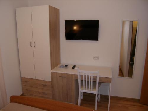 a small room with a desk and a tv on the wall at Double Room Tkon 8377d in Tkon