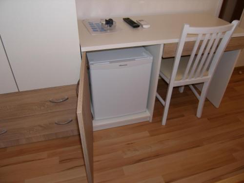 a desk with a white refrigerator and a chair at Double Room Tkon 8377d in Tkon