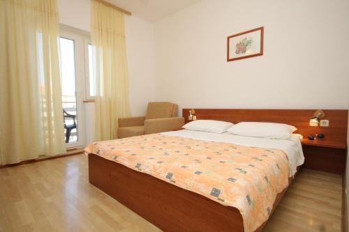 a bedroom with a bed and a chair and a window at Double Room Tkon 8377c in Tkon