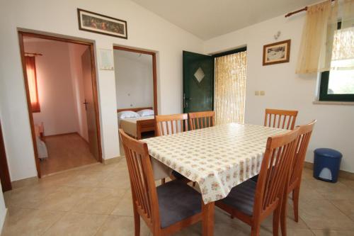 a dining room with a table and chairs and a bedroom at Seaside house for families with children Cove Sveti Ante, Pasman - 8499 in Kraj