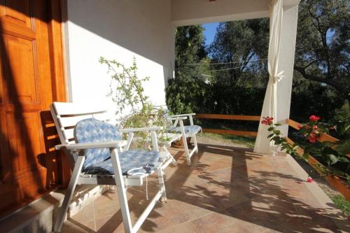 two chairs sitting on the porch of a house at Apartments and rooms with parking space Brsecine, Dubrovnik - 8541 in Zaton