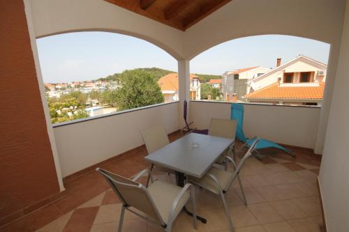 a balcony with a table and chairs and a view at Apartments by the sea Kukljica, Ugljan - 8253 in Kukljica