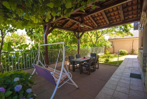 a patio with a table and chairs under a pergola at Apartments by the sea Kukljica, Ugljan - 8253 in Kukljica