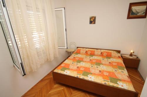 a bedroom with a bed and a window at Apartment Kukljica 8277c in Kukljica