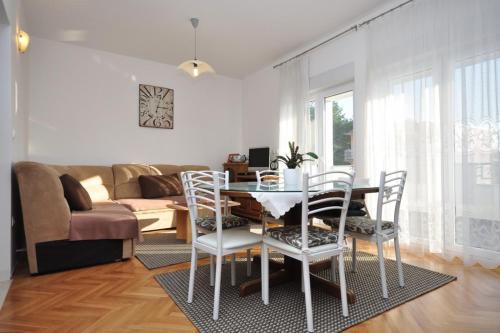 a living room with a table and chairs and a couch at Apartments by the sea Duce, Omis - 8633 in Omiš
