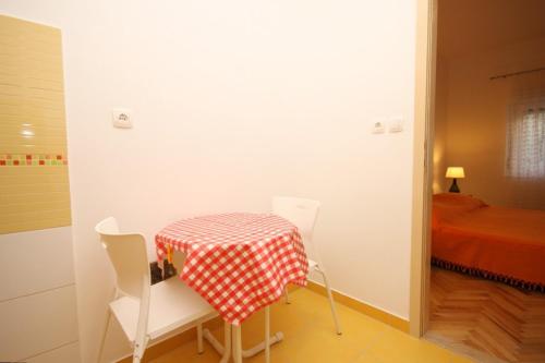 a room with a table and chairs and a bed at Apartments by the sea Duce, Omis - 8633 in Omiš