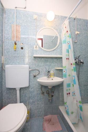 a bathroom with a toilet and a sink at Apartments by the sea Duce, Omis - 8633 in Omiš