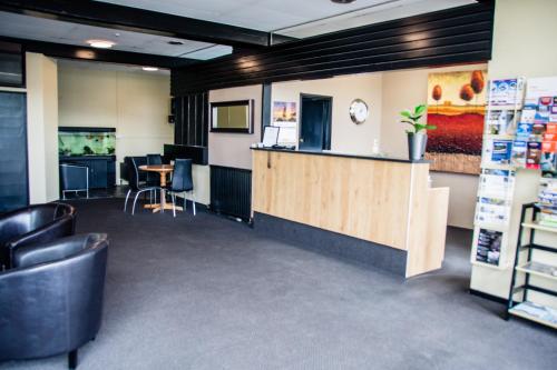 an office with a counter and a table and chairs at Fiordland Hotel in Te Anau