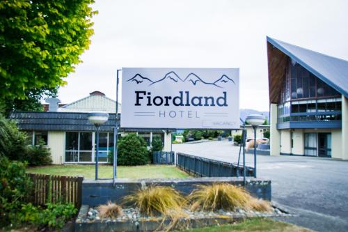 a sign for a hotel in front of a building at Fiordland Hotel in Te Anau