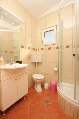 a bathroom with a toilet and a sink and a shower at Apartments by the sea Zdrelac, Pasman - 8285 in Ždrelac