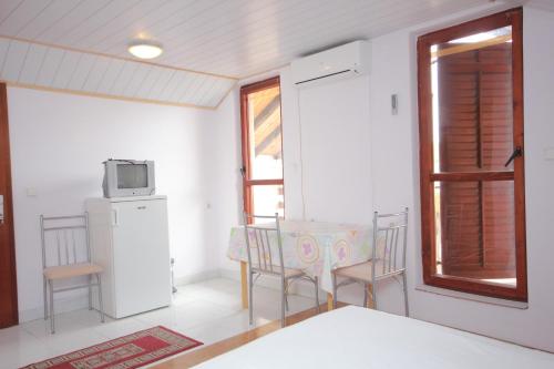a room with a table and a refrigerator and a window at Apartments by the sea Sali, Dugi otok - 8193 in Sali