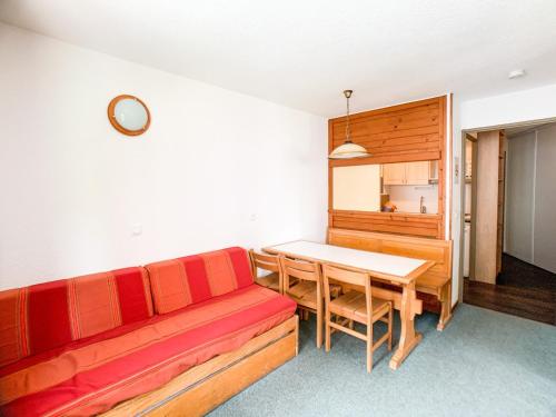un salon avec un canapé rouge et une table dans l'établissement Appartement lumineux, skis aux pieds à Tignes · Balcon ensoleillé · 2 pièces + cabine · 6 personnes - FR-1-502-401, à Tignes