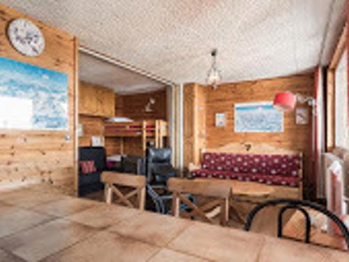 Cette chambre comprend une table, des chaises et une horloge murale. dans l'établissement Studio spacieux avec balcon près des pistes et commerces, parking optionnel, animaux acceptés - FR-1-502-424, à Tignes
