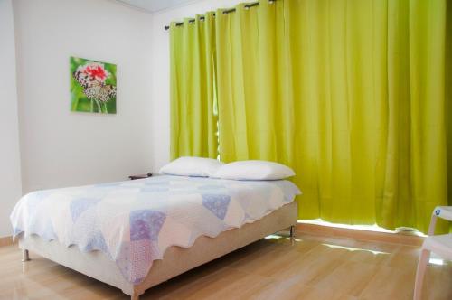 1 dormitorio con cama y cortina amarilla en Roxi's Place, en San Andrés
