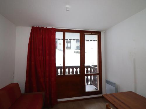 - un salon avec une porte et un rideau rouge dans l'établissement Studio 2 pers - Pied des pistes - Balcon - Animaux acceptés - FR-1-502-441, à Tignes