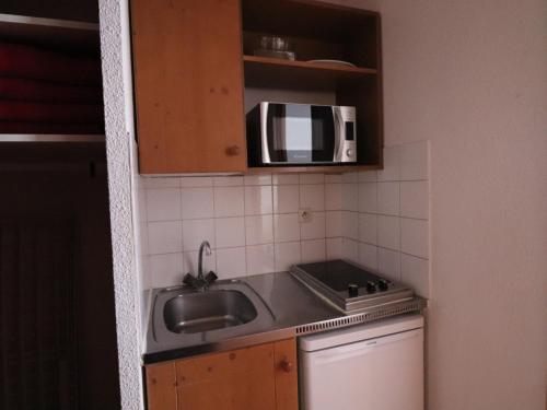 une cuisine avec un évier et un micro-ondes dans l'établissement Studio 2 pers - Pied des pistes - Balcon - Animaux acceptés - FR-1-502-441, à Tignes