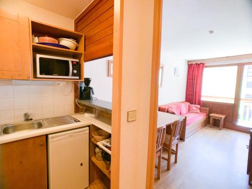 - une cuisine avec un évier et une table dans une chambre dans l'établissement Appartement lumineux 6 pers, balcon sud, accès direct pistes, au pied des commerces - FR-1-502-404, à Tignes