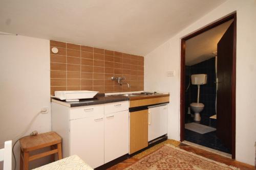 a small kitchen with a sink and a toilet at Apartments by the sea Zdrelac, Pasman - 8299 in Ždrelac