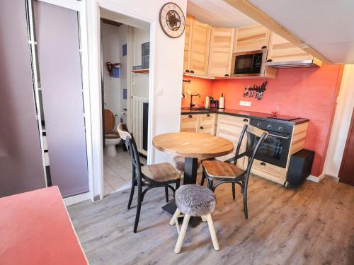 une cuisine avec une table et des chaises dans une pièce dans l'établissement Charmant studio pour 2 · Proche pistes et commerces · Balcon · Baignoire sabot - FR-1-502-439, à Tignes