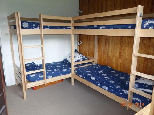 a room with three bunk beds with blue and white sheets at Appartement lumineux avec balcon, accès direct aux pistes à Tignes Le Lavachet - FR-1-502-438 in Tignes