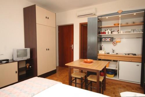 ein Schlafzimmer mit einem Bett und einem Tisch sowie eine Küche in der Unterkunft Apartments by the sea Kukljica, Ugljan - 8451 in Kukljica