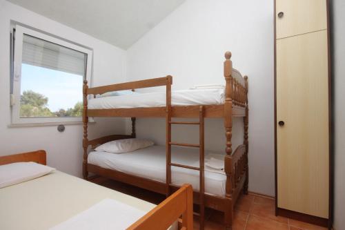 a bedroom with two bunk beds and a window at Apartments by the sea Luka, Dugi otok - 8182 in Luka