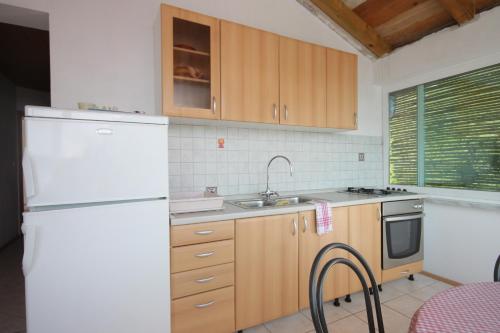 a kitchen with a white refrigerator and a sink at Apartments by the sea Luka, Dugi otok - 8182 in Luka