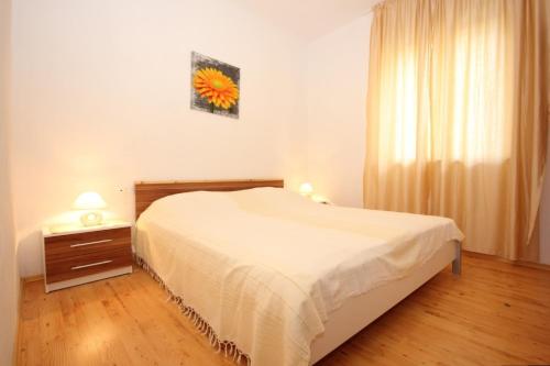 a bedroom with a white bed and a window at Apartments by the sea Zavala, Hvar - 8637 in Jelsa